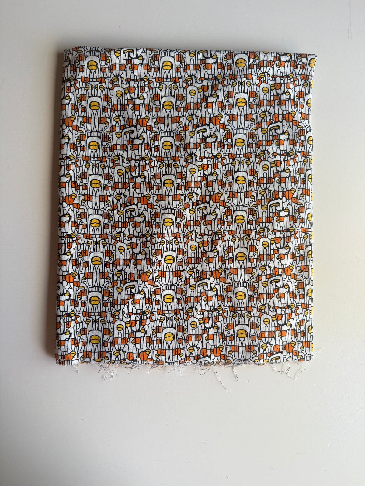 Abstract print stylized human figures in orange, yellow, and black cotton
