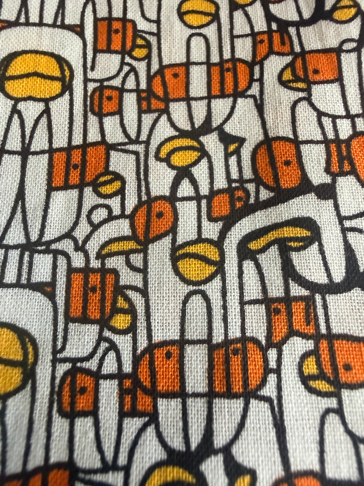 Abstract print stylized human figures in orange, yellow, and black cotton