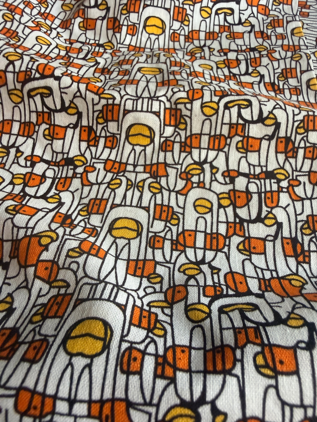 Abstract print stylized human figures in orange, yellow, and black cotton